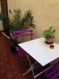 einen weißen Tisch sowie lila Stühle und Pflanzen in der Unterkunft A Picco Su Pitigliano in Pitigliano