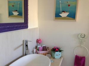 ein Badezimmer mit einem Waschbecken und einem Bild von Booten in der Unterkunft A Picco Su Pitigliano in Pitigliano