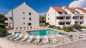 an apartment with a swimming pool next to a building at Apartment Milna in Milna