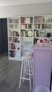 a white book shelf with a table and two stools at Le petit Ventoux in Malaucène