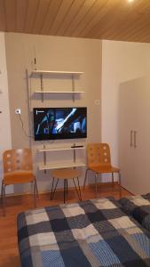 - un salon avec deux chaises et une télévision à écran plat dans l'établissement Monteur Apartment Valeria, à Hagen