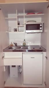 La cuisine est équipée d'un évier et d'un four micro-ondes. dans l'établissement Monteur Apartment Valeria, à Hagen