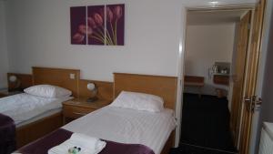 a hotel room with two beds and a mirror at The Beach Motel in Trearddur