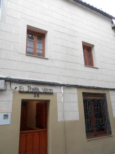 カベズエラデルバレにあるEl Portal Viejoの白い建物(木製のドア、窓3つ付)