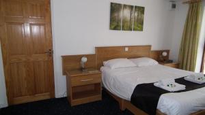 a hotel room with two beds and a door at The Beach Motel in Trearddur