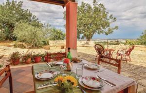 a table with plates and utensils on a patio at La Pietra in Chiaramonte Gulfi