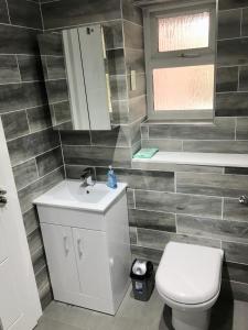 a bathroom with a toilet and a sink at Perfect Modern Base Near All Attractions in London