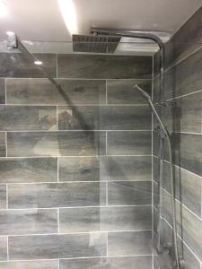 a bathroom with a shower with gray tiles at Perfect Modern Base Near All Attractions in London