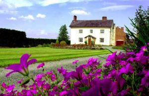 a white house with purple flowers in front of it at Hordley Hall in Ellesmere