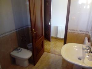 a bathroom with a toilet and a sink at Pensión Sol e Mar in O Pindo