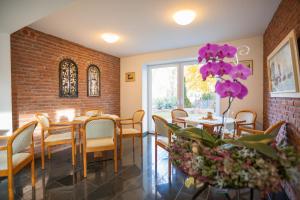 a dining room with a table and chairs and purple flowers at Parkhotel Stadthagen in Stadthagen