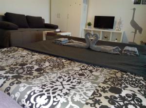 a living room with two swans laying on a bed at Studio Apartman Ždral in Daruvar