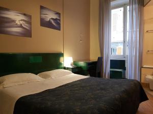 Un dormitorio con una cama grande y una ventana en Hotel Suisse, en Génova