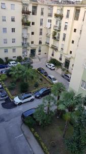 un parcheggio con auto parcheggiate di fronte a un edificio di Casa Max a Napoli
