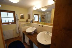 uma casa de banho com 2 lavatórios e um espelho grande em Sattelberg em Ramsau am Dachstein