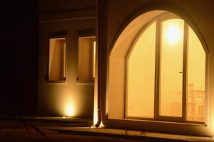 una ventana arqueada en el lateral de un edificio por la noche en Ca' Vascon Alloggio Agrituristico, en Villa Estense