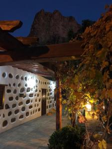 a house with a stone wall with a wooden roof at Casa Naranjo in Ayacata
