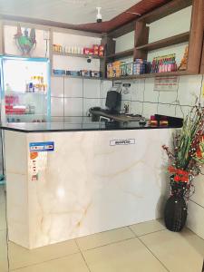 a kitchen with a counter and a refrigerator at Hotel Fortaleza III Manaus in Manaus