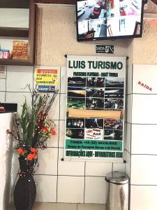a restaurant with posters on the wall and a vase with flowers at Hotel Fortaleza III Manaus in Manaus