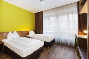 ein Hotelzimmer mit 2 Betten und einem Fenster in der Unterkunft Basic Hotel Innsbruck in Innsbruck