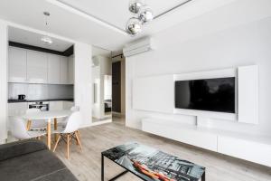 een woonkamer met een bank, een tv en een tafel bij Exclusive Trendy Apartments in Warschau