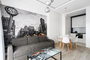 een woonkamer met een bank en een klok aan de muur bij Exclusive Trendy Apartments in Warschau