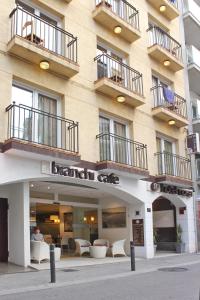 a building with a branch cafe in front of it at Hotel Norai in Lloret de Mar