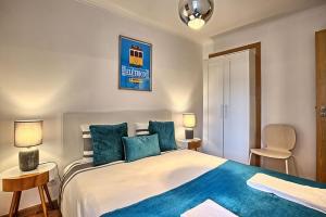 リスボンにあるSão Lazaro Apartmentのベッドルーム(青い枕の大型ベッド1台付)