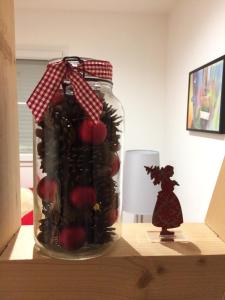 un bocal de fruits sur une table avec une figurine de sorcière dans l'établissement Gites au jardin, à Morsbronn-les-Bains