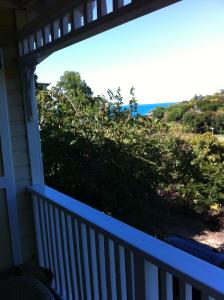 a porch with a view of a hill with flowers at Calabash Cottage in Five Islands Village