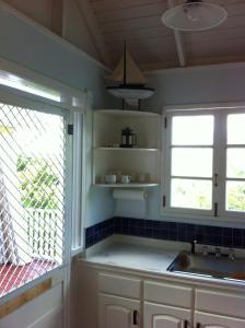 a kitchen with a sink and a window at Calabash Cottage in Five Islands Village