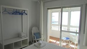 um quarto com uma cama e uma porta de vidro deslizante em Apartamento 1º linea playa Torrenueva, Motril, Granda em Torrenueva