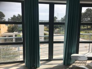 Habitación con una ventana con cortinas verdes en Prazeres do Golf, en Quinta do Anjo