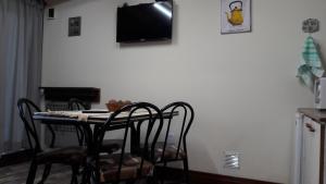 uma mesa de jantar com cadeiras e uma televisão na parede em Cabañas Oyikil em El Calafate