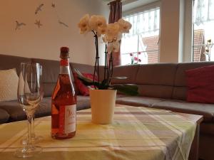butelkę wina i kieliszek na stole w obiekcie Ferienwohnung "Nordseeglück" w mieście Greetsiel