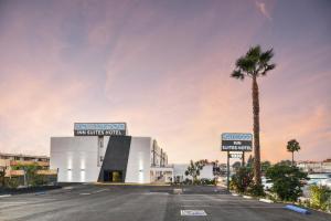 a building with a palm tree next to a street at Hollywood Inn Suites Hotel in Los Angeles