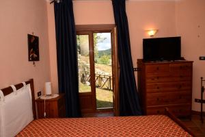 a bedroom with a bed and a television and a window at Roccaraso Relais in Roccaraso