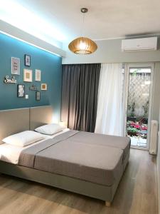 1 dormitorio con 1 cama grande y pared azul en City Vibes Kolonaki en Athens