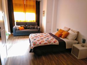 een slaapkamer met een bed en een bank bij Apartamento Domingo Lozano in Málaga