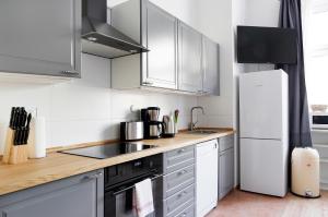 a kitchen with white cabinets and stainless steel appliances at Apartment BLISSE Large & Cozy Family & Business Flair welcomes you - Rockchair Apartments in Berlin