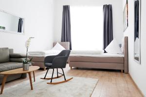 ein Wohnzimmer mit einem Sofa und einem Stuhl in der Unterkunft Apartment BLISSE Large & Cozy Family & Business Flair welcomes you - Rockchair Apartments in Berlin