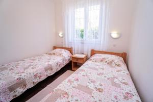 two beds in a small room with a window at Apartment Vlado in Zambratija