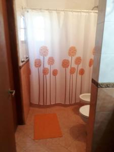 a bathroom with a shower curtain with dandelions on it at La Rosada in Potrero de Garay