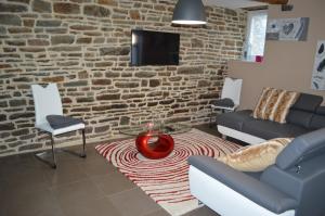 ein Wohnzimmer mit einem Sofa, einem Tisch und Stühlen in der Unterkunft Gîte de L'Hotel Mahey in Champrépus