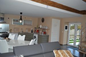 a living room with a couch and a kitchen at Gîte de L'Hotel Mahey in Champrépus