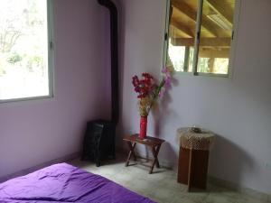 1 dormitorio con 1 cama y un jarrón de flores sobre una mesa en Sueños del Este en Costa del Este