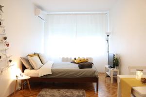 a bedroom with a bed with a large window at Studio Start in Zagreb
