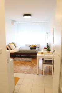a bedroom with a bed and a table and a desk at Studio Start in Zagreb