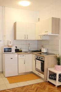 a kitchen with white cabinets and a stove top oven at Studio Start in Zagreb