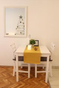 a white table and chairs with a christmas tree on the wall at Studio Start in Zagreb